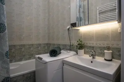 a bathroom with a sink and a toilet and a mirror at Urocze mieszkanie w krakowskiej kamienicy in Kraków