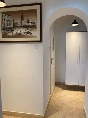 a hallway with a painting on the wall and a door at Urocze mieszkanie w krakowskiej kamienicy in Kraków