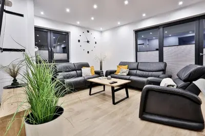 a living room with couches and a table at Domki Pod Lasem MM in Rabka