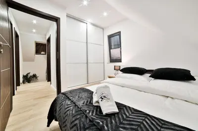 a bedroom with a large bed and a large window at Domki Pod Lasem MM in Rabka