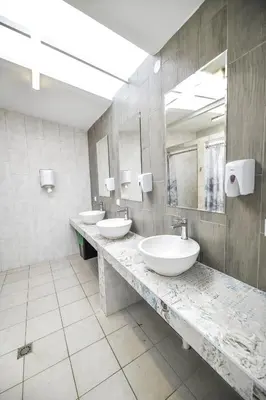 a bathroom with two sinks and two mirrors at KempingZator in Zator
