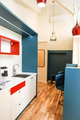 a kitchen with blue and white cabinets and a blue wall at Main Square Platan Loft Collection in Kraków