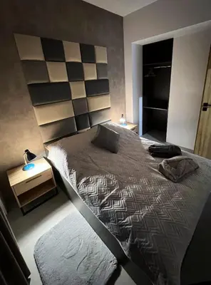 a bedroom with a large bed with a headboard at Prestige 12 in Zator