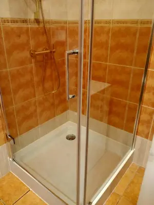 a shower with a glass door in a bathroom at Uroczy Apartament 3 in Kraków