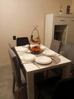a table with plates and a basket of fruit on it at Uroczy Apartament 3 in Kraków