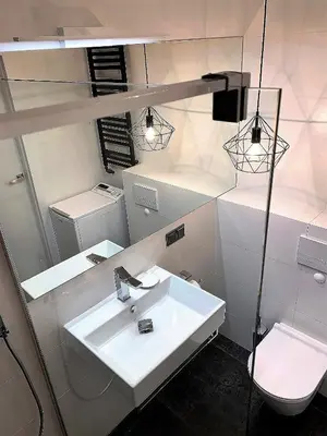 a bathroom with a white sink and a toilet at A modern apartment for 2 people in Kraków