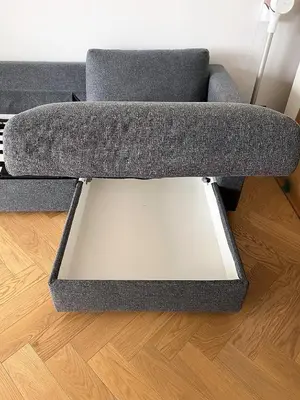 a grey couch sitting on top of a wooden floor at A modern apartment for 2 people in Kraków