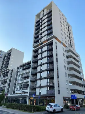a tall apartment building with cars parked in front of it at A modern apartment for 2 people in Kraków