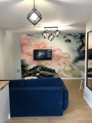 a living room with a blue couch in front of a painting at Apartament 15G in Skawina