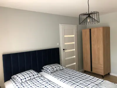 a bedroom with two beds and a chandelier at Apartament 15G in Skawina