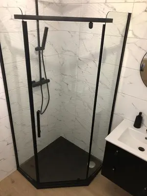 a shower with a glass door next to a sink at Apartament 15G in Skawina