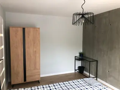 a bedroom with a bed and a chandelier at Apartament 15G in Skawina