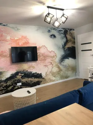 a living room with a couch and a tv on a wall at Apartament 15G in Skawina