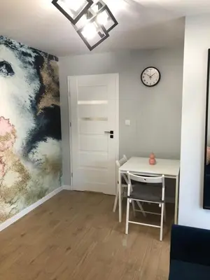 a dining room with a table and a clock on the wall at Apartament 15G in Skawina