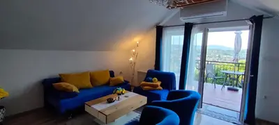a living room with a blue couch and a table at Mieszkanko z tarasem in Limanowa