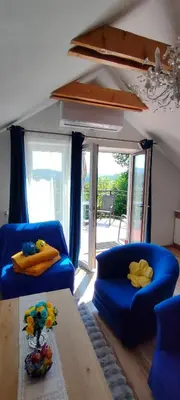 a living room with two blue chairs and a table at Mieszkanko z tarasem in Limanowa