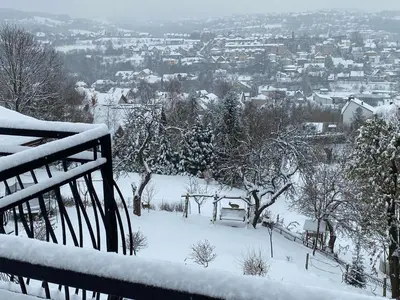 a snow covered view of a city in the distance at Mieszkanko z tarasem in Limanowa