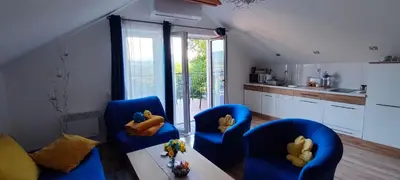 a living room with two blue chairs and a table at Mieszkanko z tarasem in Limanowa