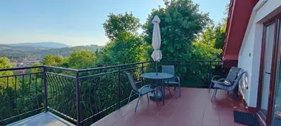 a balcony with a table and chairs and an umbrella at Mieszkanko z tarasem in Limanowa