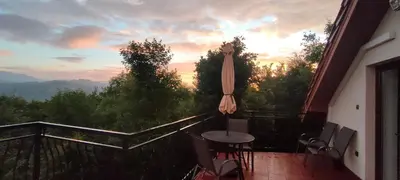 a balcony with an umbrella and a table and chairs at Mieszkanko z tarasem in Limanowa