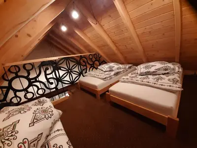 a room with two beds in a attic at Domek na szlaku RIKARDO in Ponice