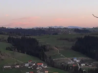 a view of a field with houses and mountains at Domek na szlaku RIKARDO in Ponice