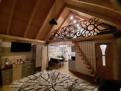 a room with a staircase and a living room with a table at Domek na szlaku RIKARDO in Ponice