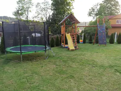 a playground with a trampoline in a yard at Domek na szlaku RIKARDO in Ponice