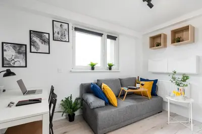 a living room with a couch and a desk at Czarnowiejska Mini Studio in Kraków