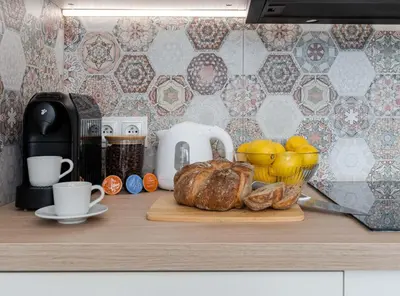 a cutting board with a loaf of bread and cups on a counter at Czarnowiejska Mini Studio in Kraków