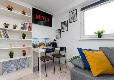 a living room with a desk and a couch at Czarnowiejska Mini Studio in Kraków