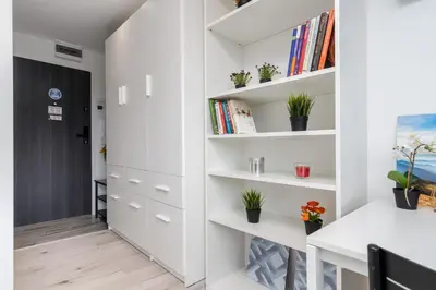a room with white shelves and a hallway at Czarnowiejska Mini Studio in Kraków