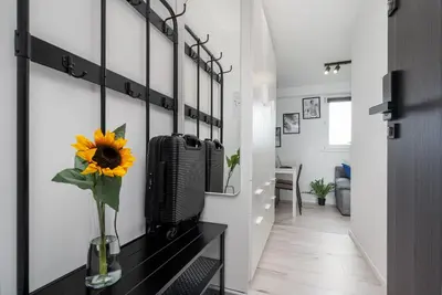 a hallway with a vase with a sunflower on a table at Czarnowiejska Mini Studio in Kraków