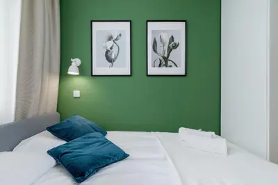 a bedroom with green walls and a bed with blue pillows at Modern Apartment on Łobzowska Street by Noclegi Renters in Kraków