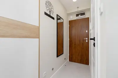 a hallway with a wooden door in a house at Modern Apartment on Łobzowska Street by Noclegi Renters in Kraków