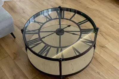 a glass table with a clock on top of a floor at Modern Apartment on Łobzowska Street by Noclegi Renters in Kraków