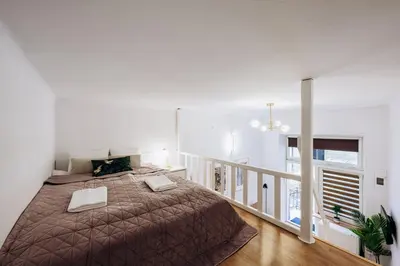 a bedroom with a large bed and a staircase at NEST Cosy Apt Old Town & Wawel Hill by Vistula River - by Homelike Krakow in Kraków