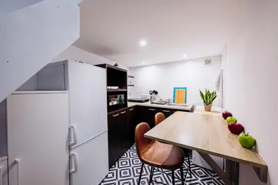 a kitchen with a wooden table and a refrigerator at NEST Cosy Apt Old Town & Wawel Hill by Vistula River - by Homelike Krakow in Kraków