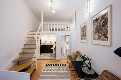 a living room with a staircase and a desk at NEST Cosy Apt Old Town & Wawel Hill by Vistula River - by Homelike Krakow in Kraków
