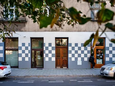 a woman standing outside of a building with checkerboard at NEST Cosy Apt Old Town & Wawel Hill by Vistula River - by Homelike Krakow in Kraków