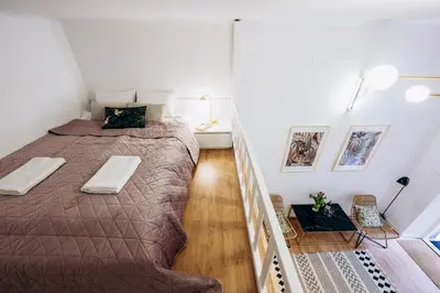 a bedroom with a large bed and a staircase at NEST Cosy Apt Old Town & Wawel Hill by Vistula River - by Homelike Krakow in Kraków