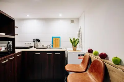 a kitchen with wooden cabinets and a chair in it at NEST Cosy Apt Old Town & Wawel Hill by Vistula River - by Homelike Krakow in Kraków