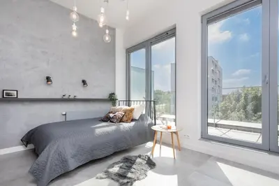 a bedroom with a bed and a large window at Kraków Loft in Kraków