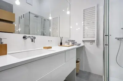 a white bathroom with a sink and a shower at Kraków Loft in Kraków