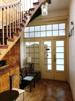 a living room with stairs and chairs and a fireplace at Pod Słońcem - Rynek Główny in Kraków