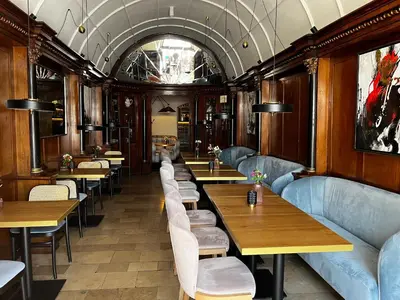 a dining car of a train with tables and chairs at Pod Słońcem - Rynek Główny in Kraków