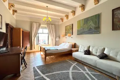 a living room with a couch and a bed at Pod Słońcem - Rynek Główny in Kraków