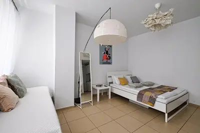 a white bedroom with a bed and a mirror at Urban Nest Apartments Radziwiłłowska 12 in Kraków