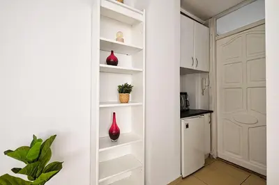 a kitchen with white cabinets and red vases on shelves at Urban Nest Apartments Radziwiłłowska 12 in Kraków