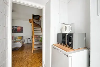 a small room with a microwave and a staircase at Urban Nest Apartments Radziwiłłowska 12 in Kraków